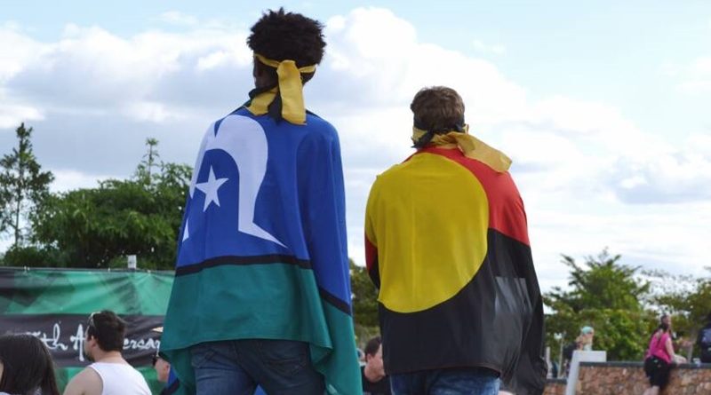 2 men walking with flags on their back